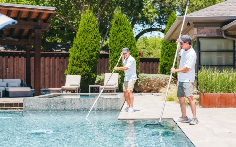 Pulliam Pools staff cleaning a swimming pool.