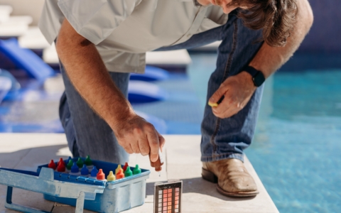 Maintenance guy testing pool water.