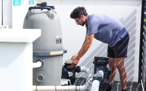 Man carrying out pool equipment maintenance.