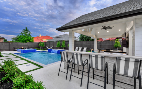 Outdoor pool area with seats and tv.