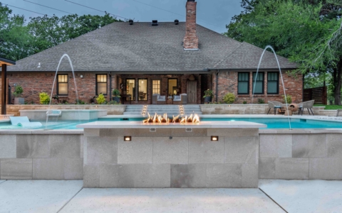 Pool with water sprinklers and fire pit.