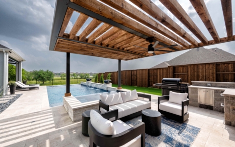 Outdoor kitchen area with barbecue and seats.